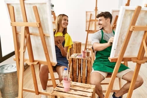 a man and a woman in a painting class