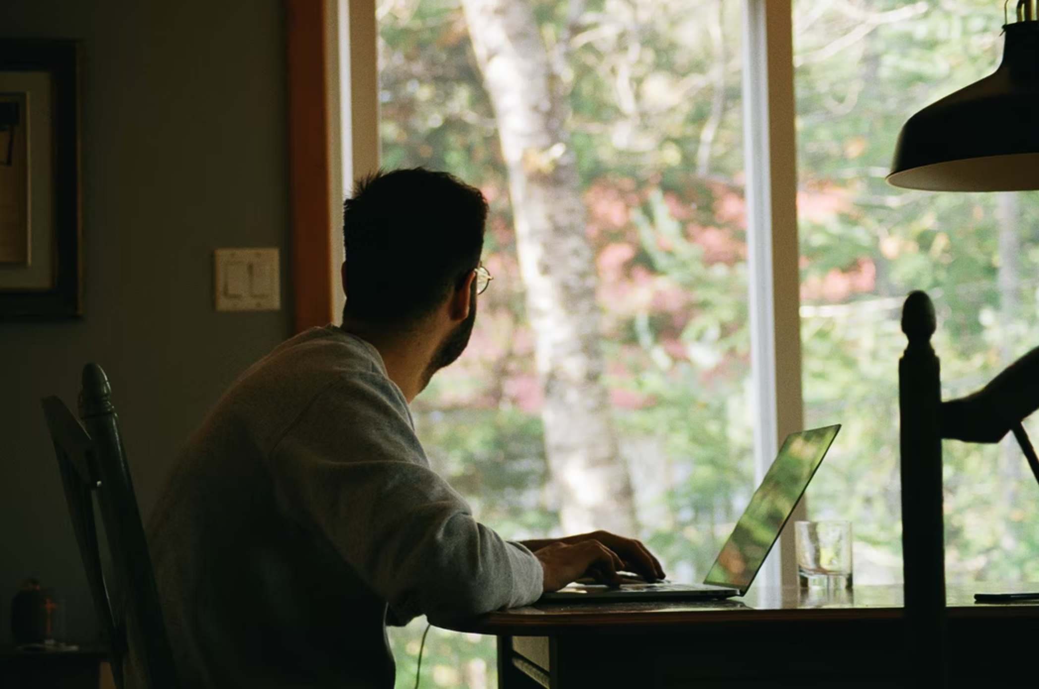 guy working remotely and looking out of a window