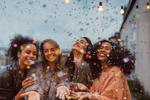 smiling women with confetti